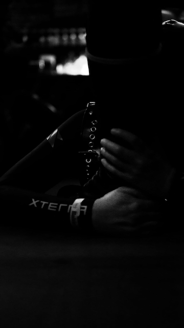 Hands fastening a leather harness buckle in low light